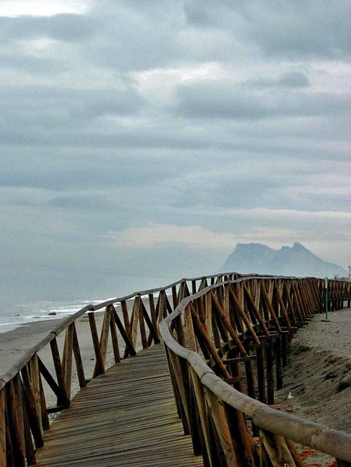 The boardwalk that used to be in place along the beach with Gibraltar in the background